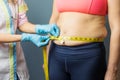 Doctor taking obese patient`s body fat measurements Royalty Free Stock Photo