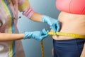 Doctor taking obese woman`s body fat measurements