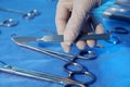 Doctor taking scalpel from table with different surgical instruments indoors, closeup Royalty Free Stock Photo