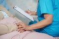 Doctor talking about diagnosis and note on clipboard with Asian senior or elderly old lady woman while lying on bed in nursing hos Royalty Free Stock Photo