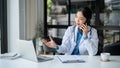 A doctor is talking on the phone with her patient while working in her hospital office Royalty Free Stock Photo