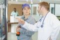 doctor talking to female maintenance worker in hospital