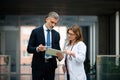 Doctor talking to pharmaceutical sales representative, presenting new medication. Hospital manager talking with female Royalty Free Stock Photo