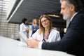 Doctor talking to pharmaceutical sales representative, shaking hands. Hospital manager talking with female doctor. Royalty Free Stock Photo