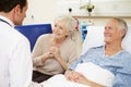 Doctor Talking To Senior Couple By Hospital Bed Royalty Free Stock Photo