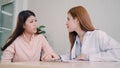 Doctor talking to unhappy teenage patient in exam room. Asian woman doctor encouragement and support to cancer patient after Royalty Free Stock Photo