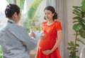 Doctor talks with the pregnant woman near window