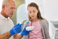 Doctor teaching child patient on how to properly brush teeth