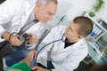 Doctor teaching young apprentice how to take blood pressure Royalty Free Stock Photo