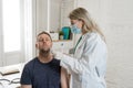 Doctor testing adult man for coronavirus infection performing nasal swab, PCR or rapid COVID-19 test