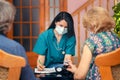 Doctor testing senior people blood oxygen using pulse oximeter during home visit Royalty Free Stock Photo