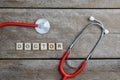 Doctor text word made with wood blocks and Red Heart,stethoscope on wooden table