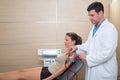 Doctor therapist checking muscle electrostimulation to woman