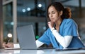 Doctor, thinking and writing with laptop at night for healthcare solution, idea or planning at hospital. Woman medical Royalty Free Stock Photo