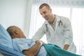 Doctor touching hands to encouragement mental of elderly patient after surgery at bed in hospital Royalty Free Stock Photo