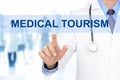 Doctor touching MEDICAL TOURISM sign on virtual screen Royalty Free Stock Photo