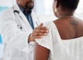 Doctor touching a patient on the shoulder in support. Closeup on hand of doctor being kind to a patient in a checkup Royalty Free Stock Photo