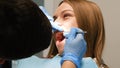 A doctor treats a young woman& x27;s teeth with dental instruments. Royalty Free Stock Photo