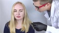 A doctor trichologist conducts a study of the hair of a blonde. Alopecia treatment. Hair loss, alopecia, itching, burning in the