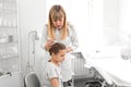 Doctor trichologist examines the hair of a little girl patient in his office