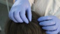 Doctor trichologist is examining woman skin on head in clinic, closeup view.