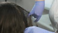 Doctor trichologist makes injections in woman`s skin on head for hair growth.