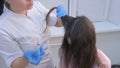 Doctor trichologist making injections mesotherapy in woman head skin for hairs.