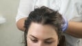 Doctor trichologist massaging woman`s head skin after mesotherapy injections.