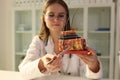 Doctor trichologist showing artificial model of human skin with hair in clinic closeup