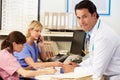 Doctor With Two Nurses Working At Nurses Station Royalty Free Stock Photo