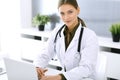 Doctor typing on laptop computer while sitting at the desk in hospital office. Physician woman at work. Data in medicine Royalty Free Stock Photo