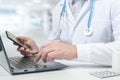 Doctor typing on laptop computer while sitting at the glass desk in hospital office. doctor working in clinic. Doctor is with Royalty Free Stock Photo