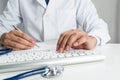 Doctor typing on wireless computer keyboard Royalty Free Stock Photo