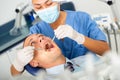 Doctor in uniform is examinating man on chair in hospital