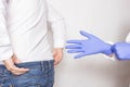Doctor urologist puts a medical glove on the arm to examine the patient`s prostate, prostate massage, lymphatic drainage
