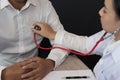 Doctor use stethoscope to examine pulse rate on patient chest at