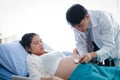 The doctor uses a stethoscope to examine a woman`s pregnancy Royalty Free Stock Photo