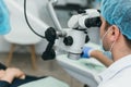 Doctor used microscope. Dentist is treating patient in modern dental office. Operation is carried out using cofferdam Royalty Free Stock Photo