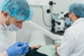 Doctor used microscope. Dentist is treating patient in modern dental office. Operation is carried out using cofferdam Royalty Free Stock Photo