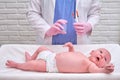 The doctor uses a syringe to inject a newborn child. A nurse in uniform is preparing to vaccinate a child Royalty Free Stock Photo