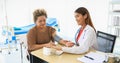 The Doctor using blood pressure gauge for checking to old women patients in his office at Hospitals