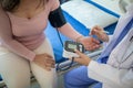 The doctor is using a blood pressure monitor on an elderly patient to check whether the blood pressure is abnormally high or not