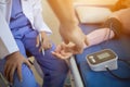 The doctor is using a blood pressure monitor on an elderly patient to check whether the blood pressure is abnormally high or not