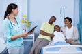 Doctor using digital tablet while parents interacting with patient Royalty Free Stock Photo