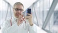 Doctor using his smartphone for telemedicine session with a patient Royalty Free Stock Photo