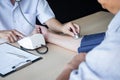 Doctor using a measuring blood pressure checking patient with examining, presenting results symptom and recommend treatment method Royalty Free Stock Photo