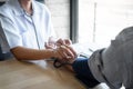 Doctor using a measuring blood pressure checking patient with examining, presenting results symptom and recommend treatment method Royalty Free Stock Photo