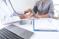 Doctor using a measuring blood pressure checking patient with examining, presenting results symptom and recommend treatment method Royalty Free Stock Photo