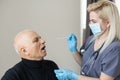 Doctor using nose swab test coronavirus COVID-19 with senior elderly male in hospital. Medical examination for COVID-19 Royalty Free Stock Photo