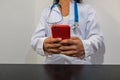 Doctor using smartphone on the table in the hospital room, telemedicine or videoconferencing, concept of electronic health record